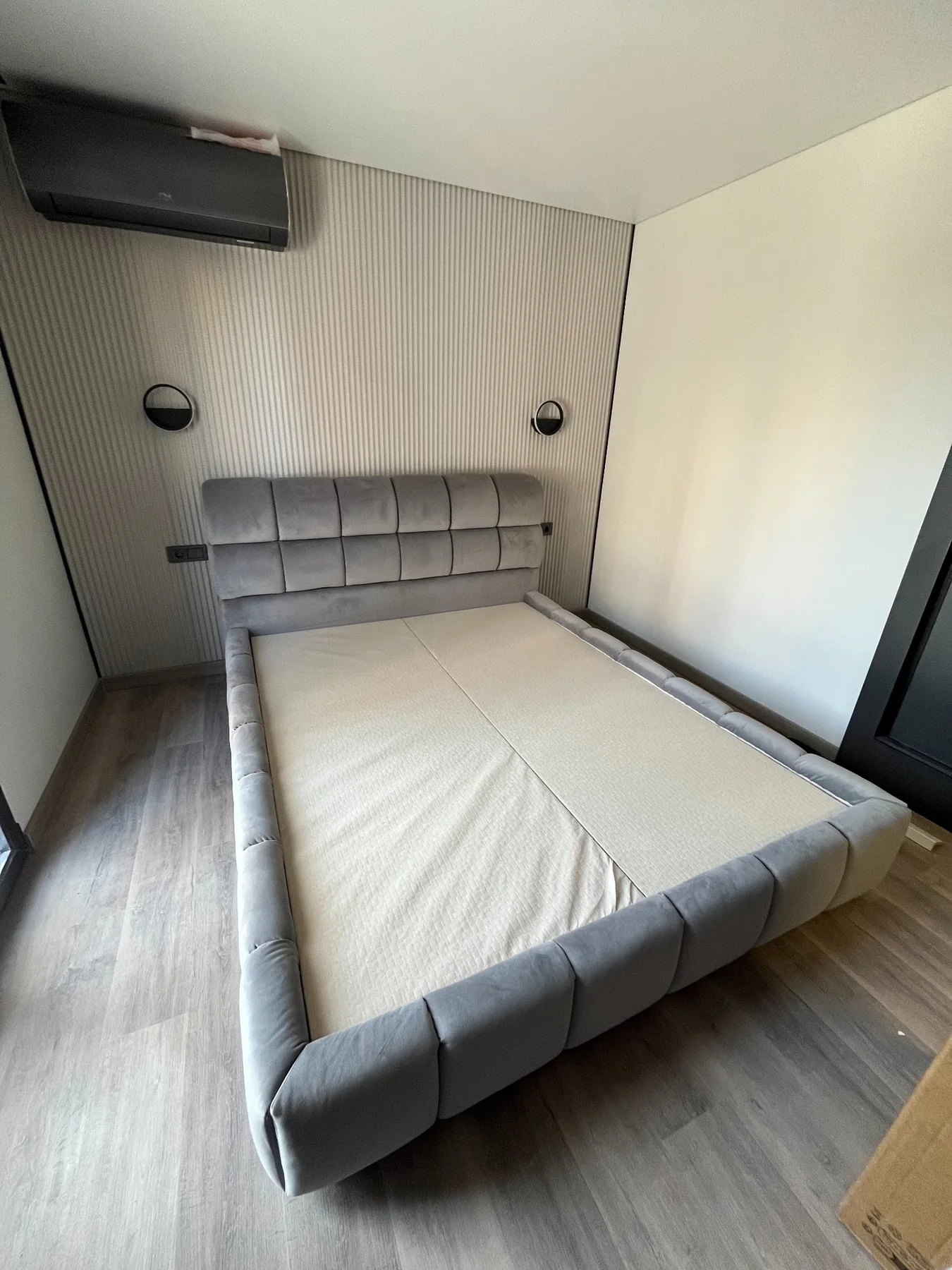 Cama tapizada con cabecero panelado